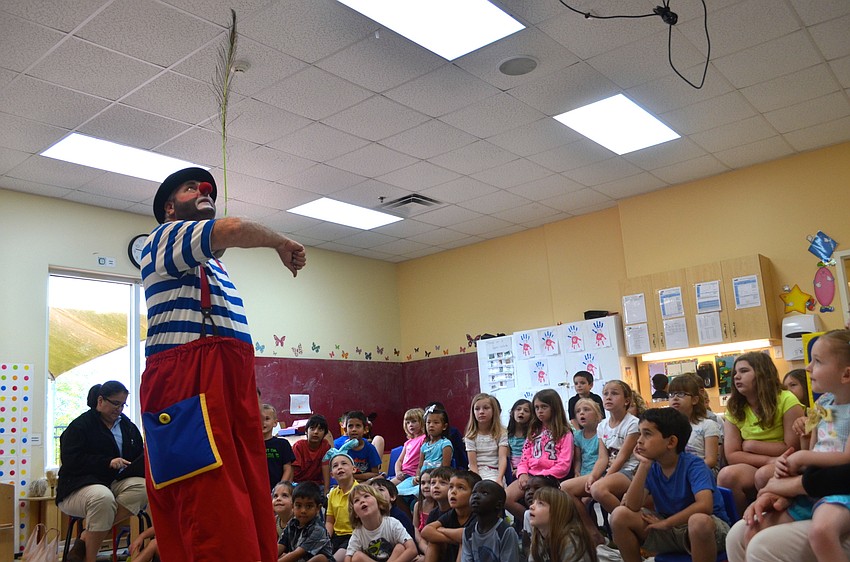 Juggles the Clown shows children how to balance a feather.