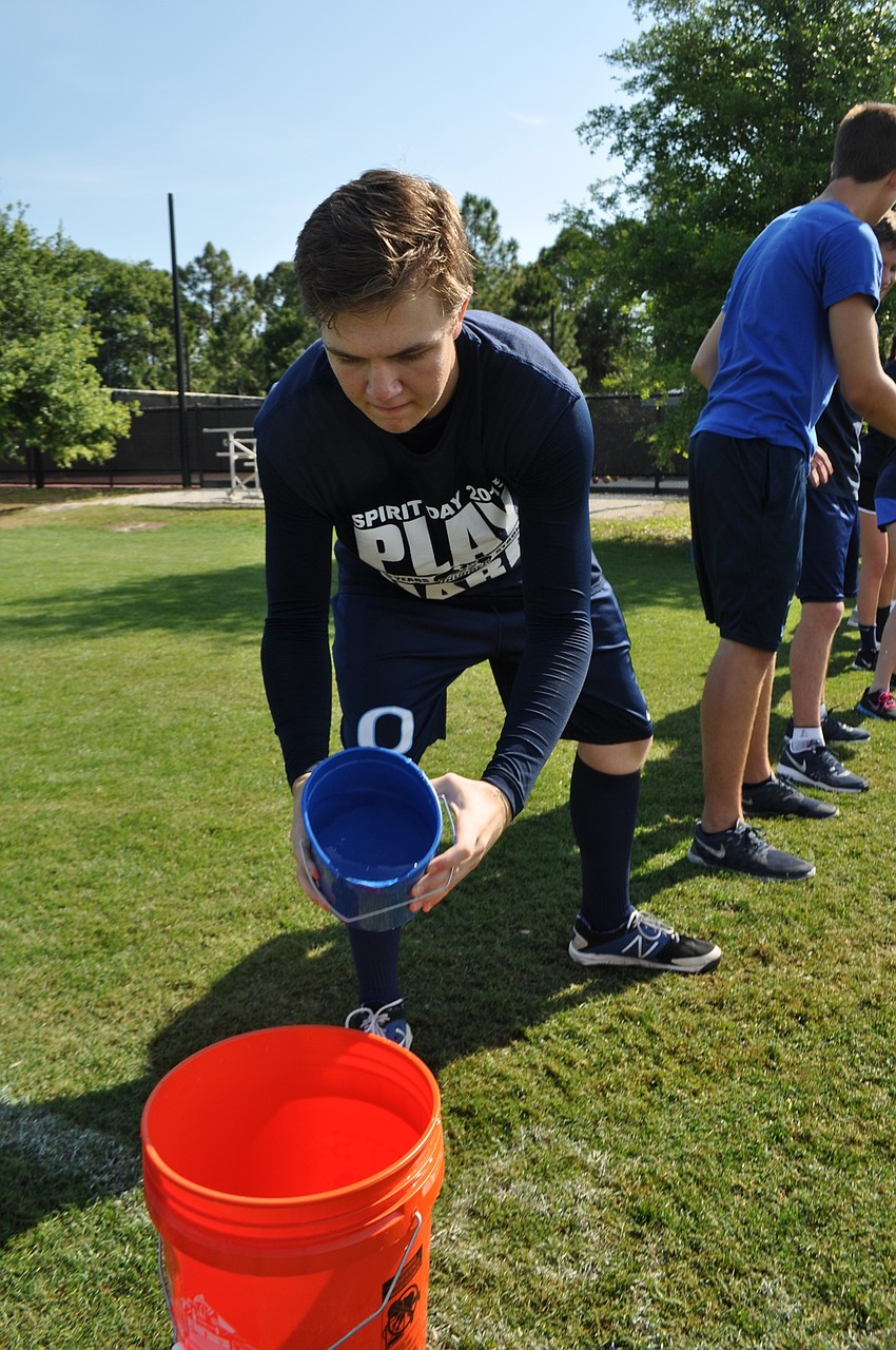 Duncan Cappar fills a bucket with water for the bucket brigade game.