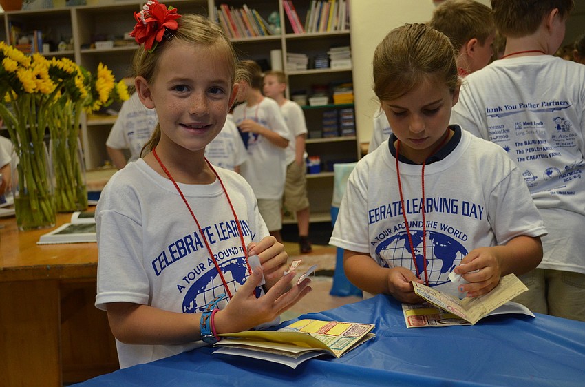 Liza Strong and Katelyn Turgeon add stamps to their passports.
