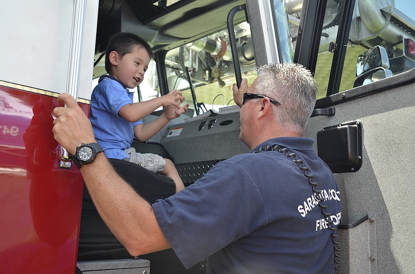 Hayden Khuu, 3, talks with Glenn Galbraith, a firefighter from Station 11.
