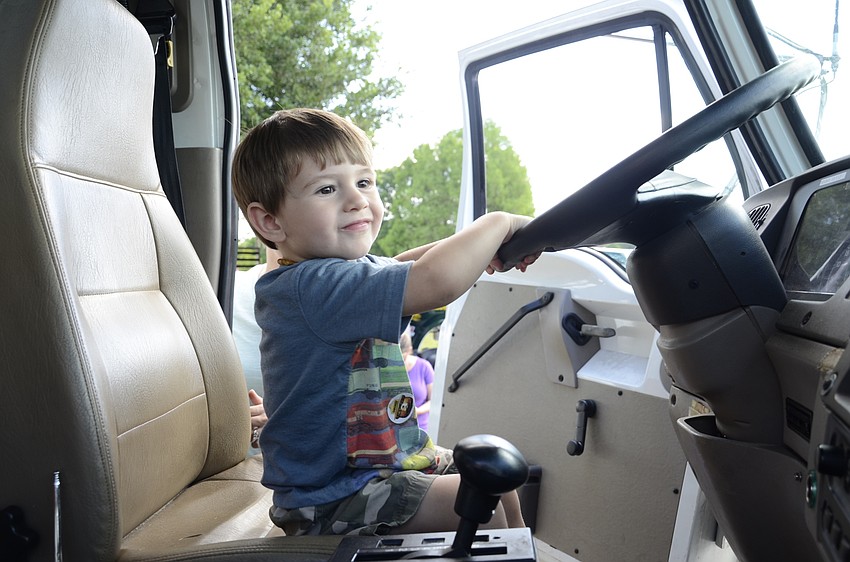Julian Drass, 2, steers the Florida State Department of Forestry's truck.