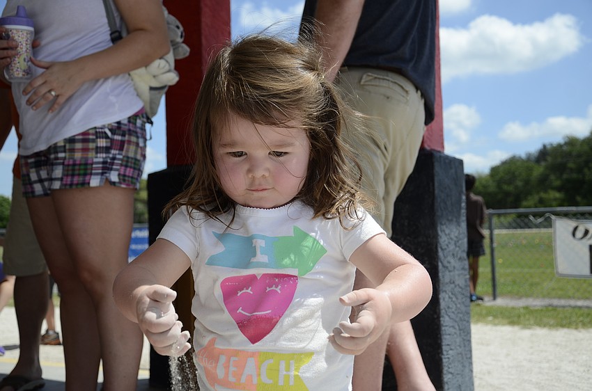 Maggie Whitley, 2, plays and waits for the Easter egg hunt.