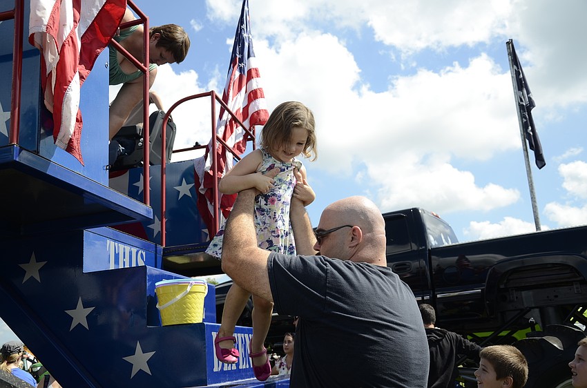Devin Slegeski helps his daughter Paige, 3, down from the swamp buggy.