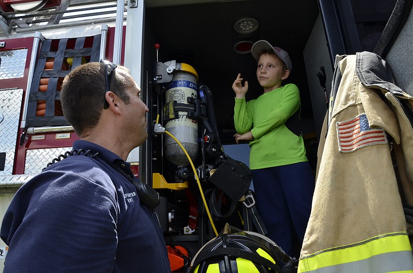 Steele Jackson, 8, asks Gary Terpak, from Station 11, how big fires are put out.