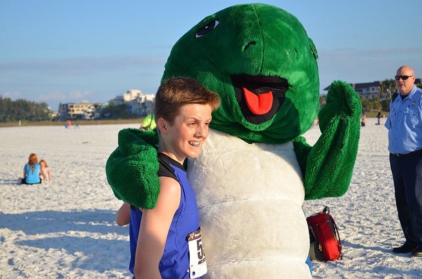 Overall winner Ben Olson with Shelly the turtle after crossing the finish line.