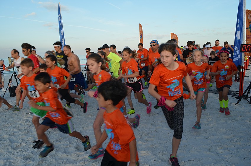 Runners start the course for the 5K Run for the Turtles on Siesta Beach.