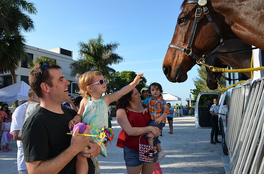 Chris and Avery Huver lean in to say hello to Sarasota County Sheriff’s Mounted Patrol horse Valor.