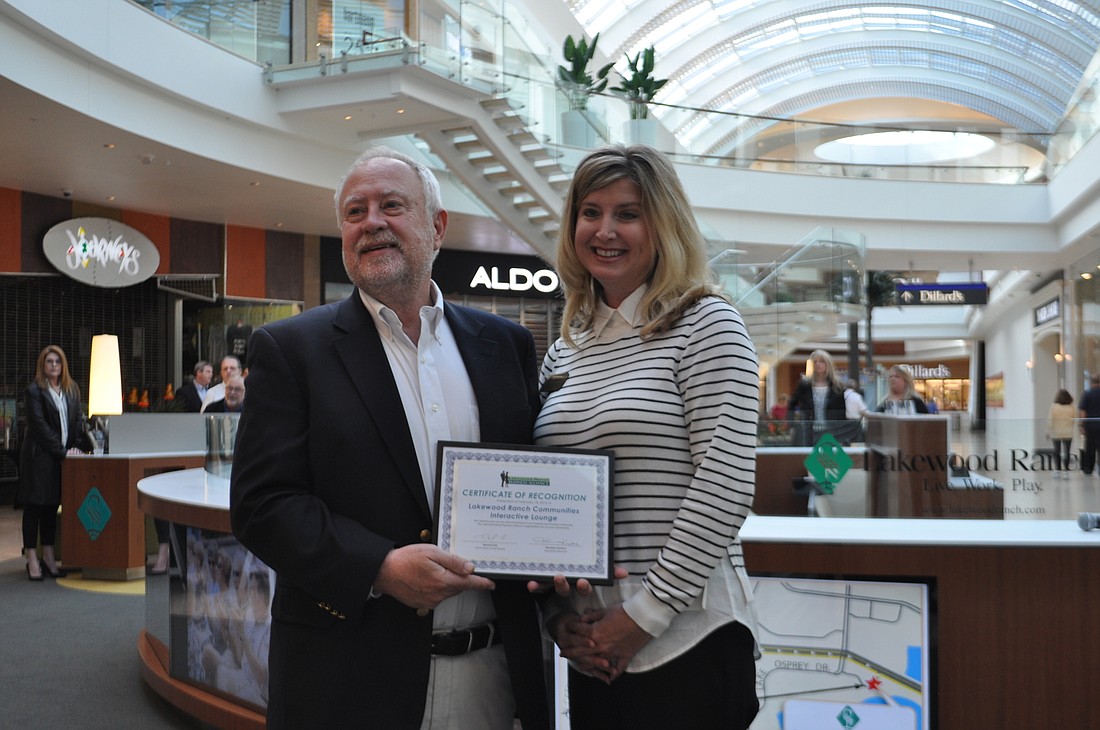 Schroeder-Manatee Ranch President and CEO Rex Jensen accepts a certificate from Lakewood Ranch Business Alliance Executive Director Heather Kasten.