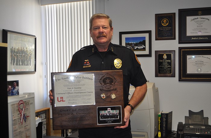 Longboat Key Police Chief Pete Cumming holds the plaque he received at his Feb. 13 graduation ceremony.