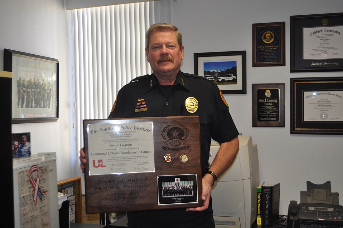 Longboat Key Police Chief Pete Cumming holds the plaque he received at his Feb. 13 graduation ceremony.