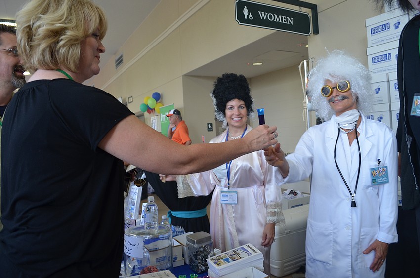 Cathy Stevens gives Deborah Vaughan a test tube of sangria.