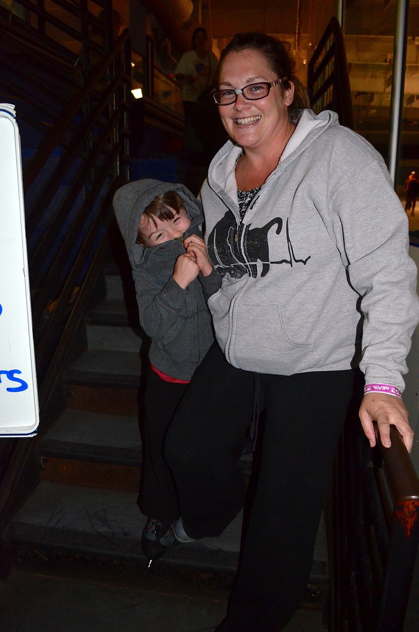 Mason McNeel bundles up next to his mother, Jamie, after skating on the cold rink.