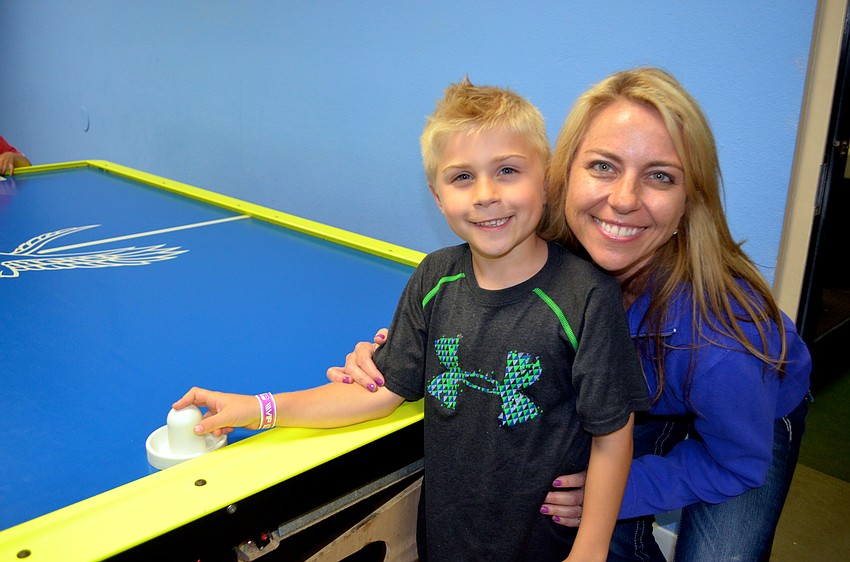 Bryce Wilson spends his Friday night with his mother, Jennifer, at the air hockey table.