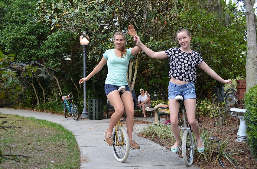 Alice Hafner and Khera Lorraine show off their unicycles at the neighborhood picnic Tunes in the Park.