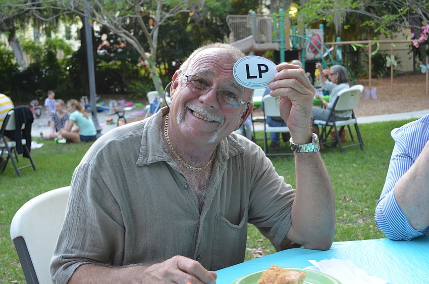 Grego DiBona shows off the Laurel Park stickers that were given out at Tunes in the Park.