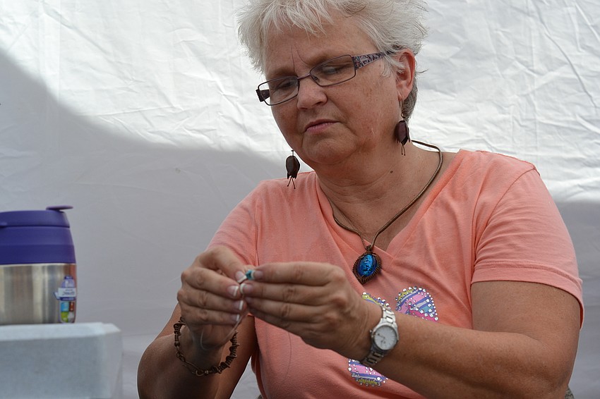 Ellen Robins adds pieces to a turquoise necklace for her Turtle Trinkets.