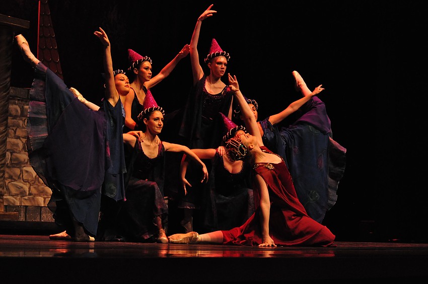 The Queen, played by Rebecca Kimsey, dances in front of her with her princesses.