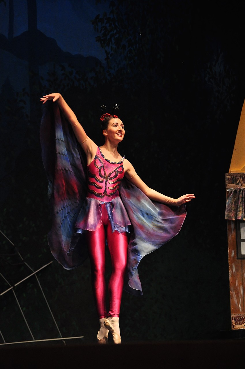 Andie Herrig, a butterfly, flutters across the stage.