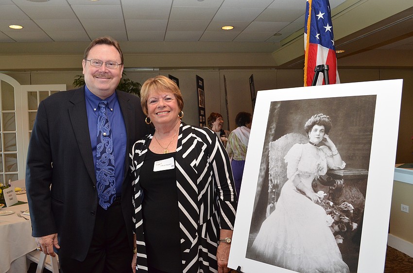 Curator for the Ca‘dZan Ron McCarty and Sarasota Garden Club President Olivia Haynes with a portrait of Mable Ringling from 1905.