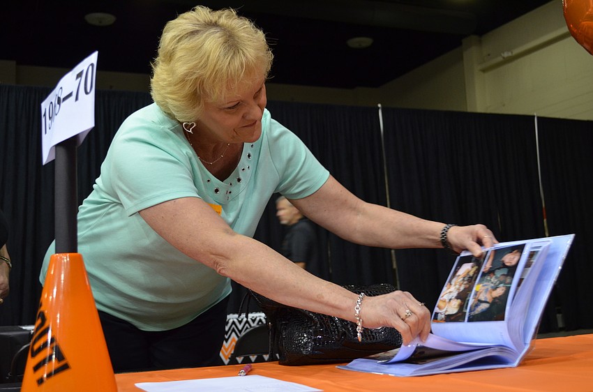 Cheryl Hammond Paetsh looks through a photo album for the class of 1968.