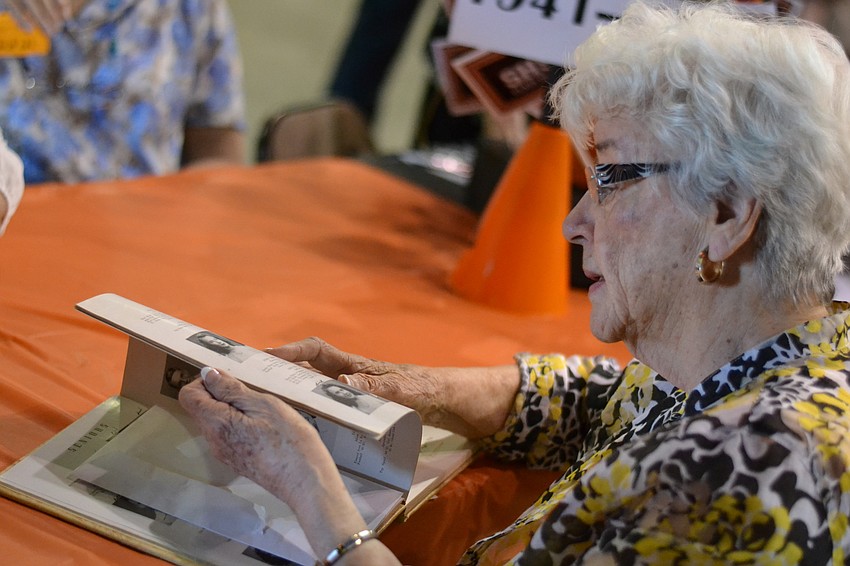 Graduate of the class of 1947 Evelyn West looks for her photo in the yearbook.