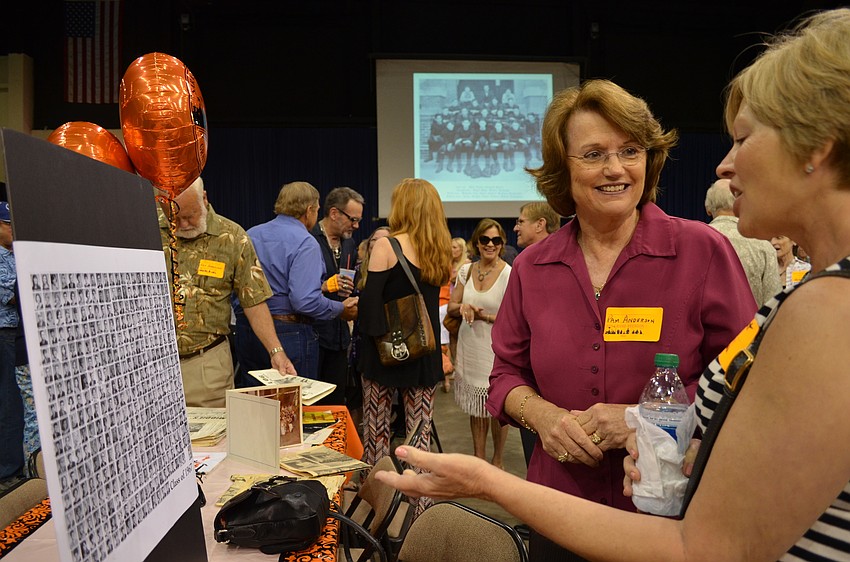 Pam Anderson and Connie West look for photos of their husbands who graduated from Sarasota High School.