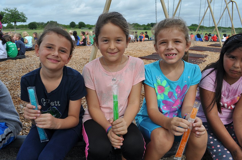 Brianna Camann, Alice Shneyderman and Elizabeth Fayette munch on icy pops after completing their laps.