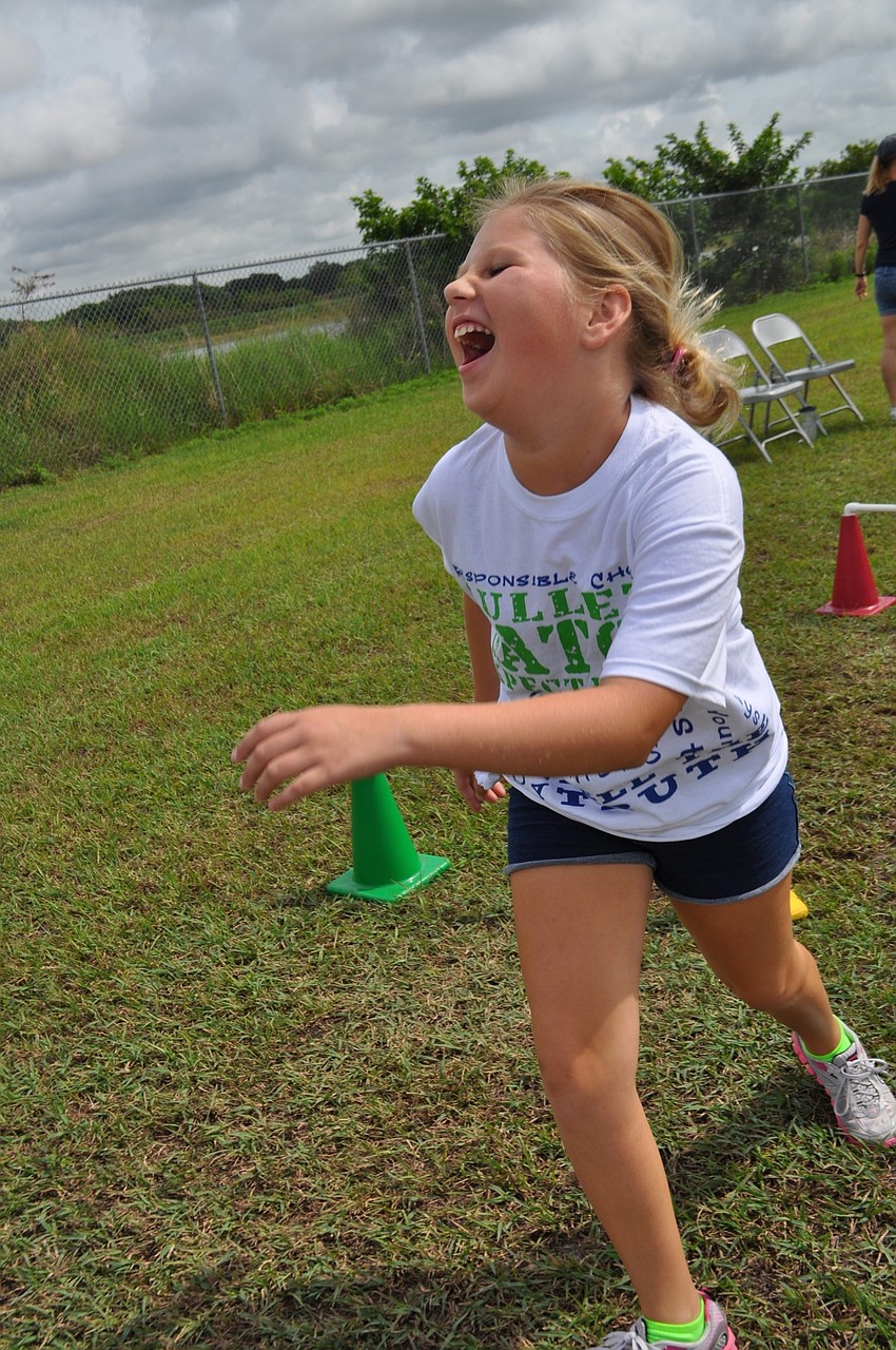 Veronica White, 11, laughs after knocking over hurdles.