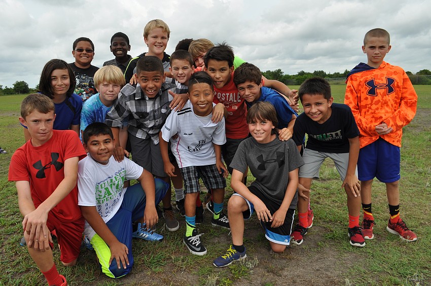 A group of fifth-grade boys pile in for a photo after completing several laps on the course.