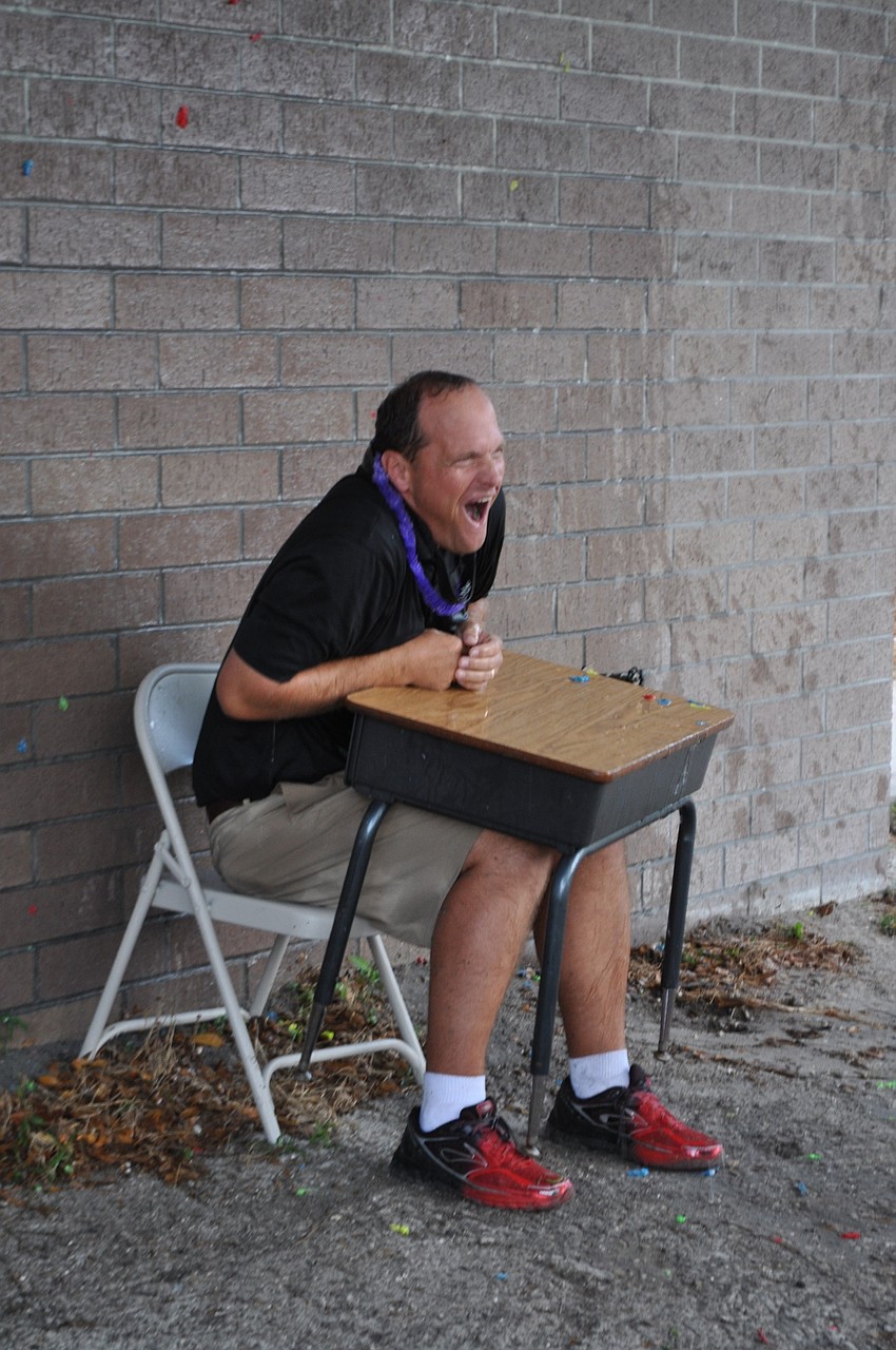“I’ve got a lot of extra homework to give a lot of kids who aren’t even in my class,” teacher Chuck Rogalla said after being blasted with water balloons by cheering children as part of a fundraiser.