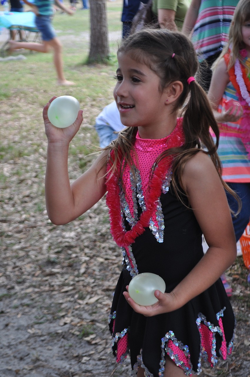 Isabella Oliveira, 7, gleefully throws a water balloon at teacher Chuck Rogalla.