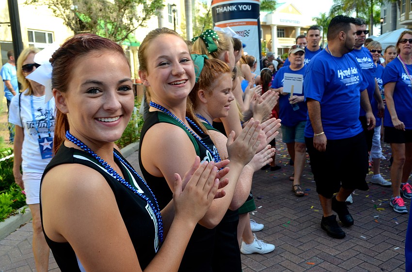 Lakewood Ranch High cheerleaders Holly MacLeod and Sarah Dill cheer for the crowd members as they start walking.
