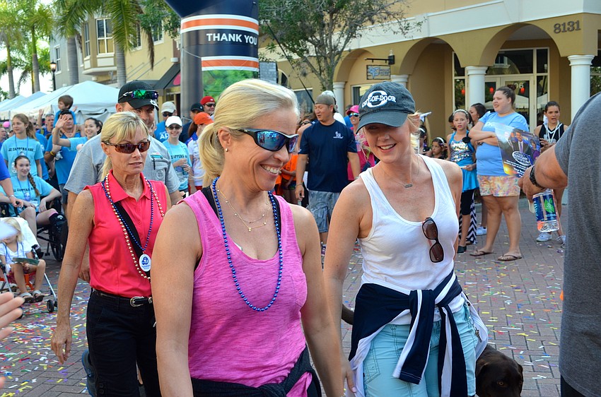 Sue McCann and Christi Wheeler chat while walking the 5k.