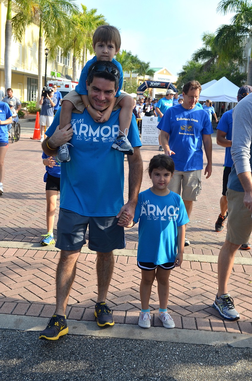 Daniel Zeballo walks for the cause with his son, Carlos, atop his shoulders, and his daughter, Ariana, beside him