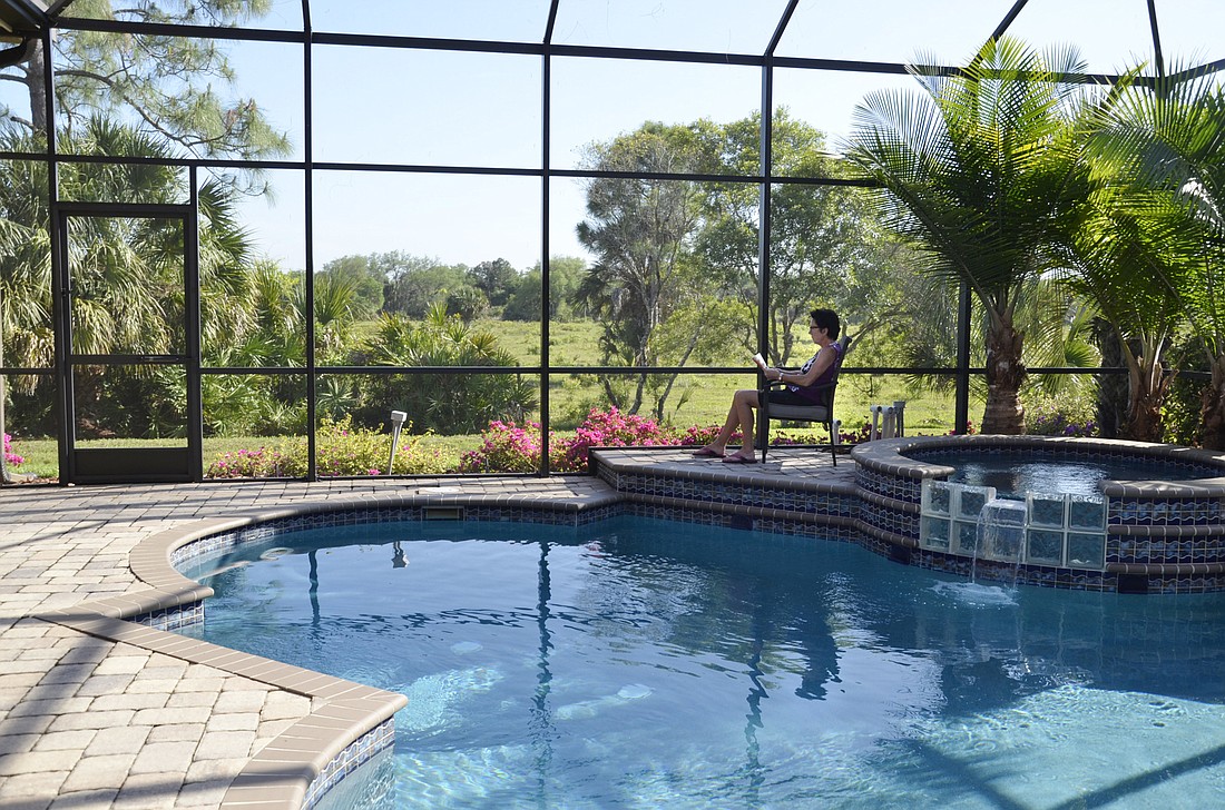 Lilli Hernler sits by the pool at her Silver Oaks home, which overlooks the now-vacant cattle pasture.