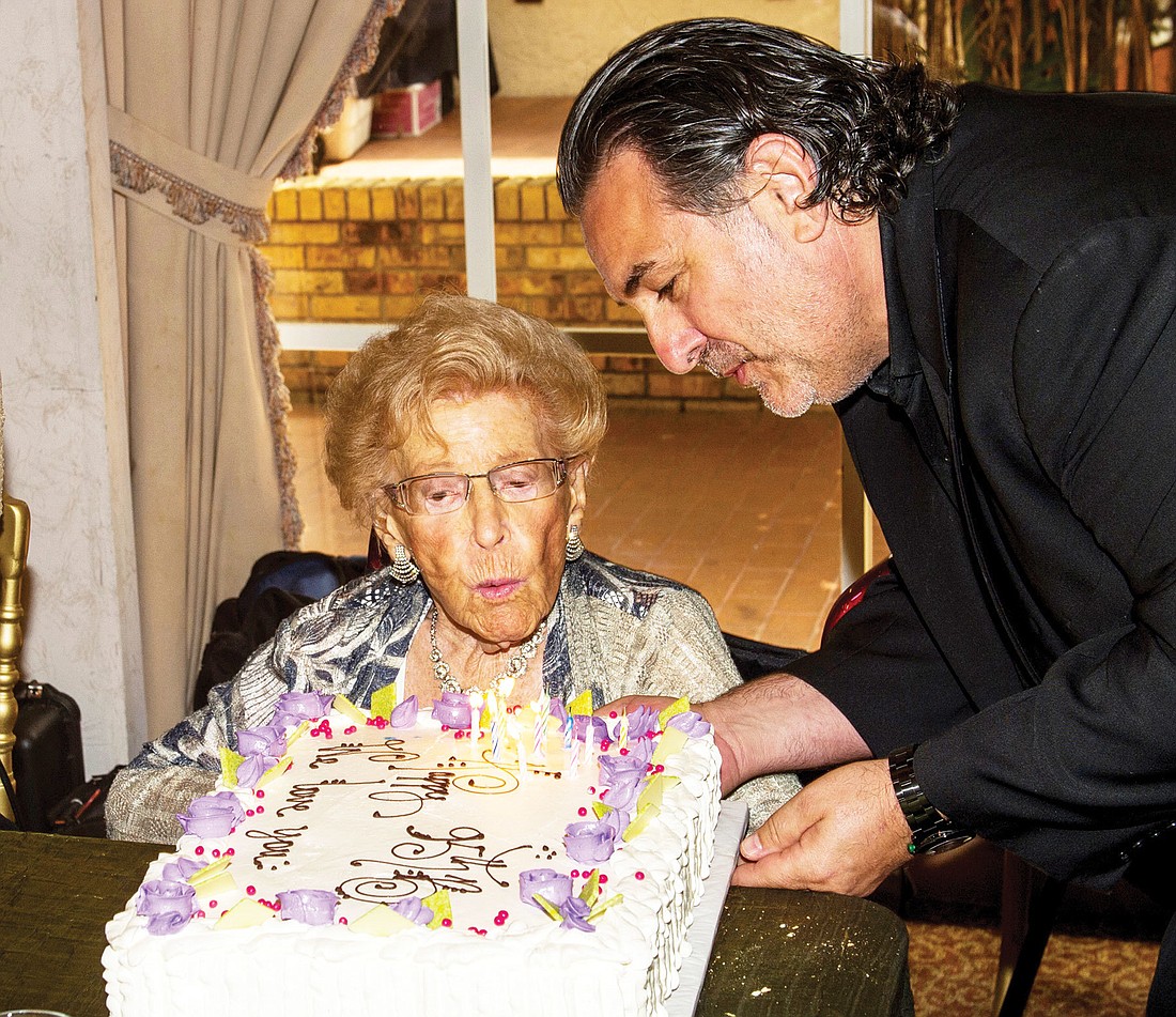 Phil Mancini presents Beatrice Friedman with her birthday cake. Photo by Cliff Roles.