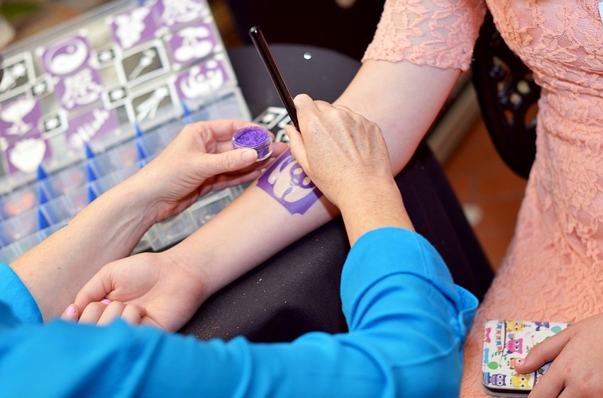 Jayne Meyers gets a glitter tattoo at Cooking for Wishes.