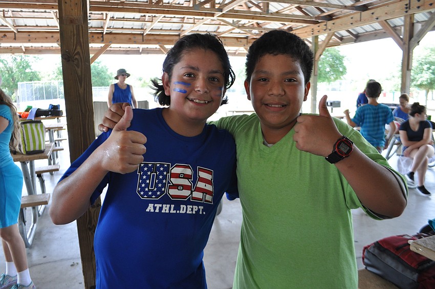 Nick Rossman and Diego Taylor, both 12, cool off with water under the pavilion.