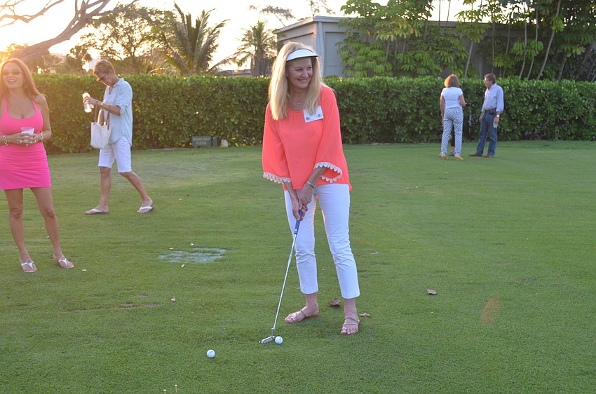 Event chair Susan Phillips participates in the putting competition.