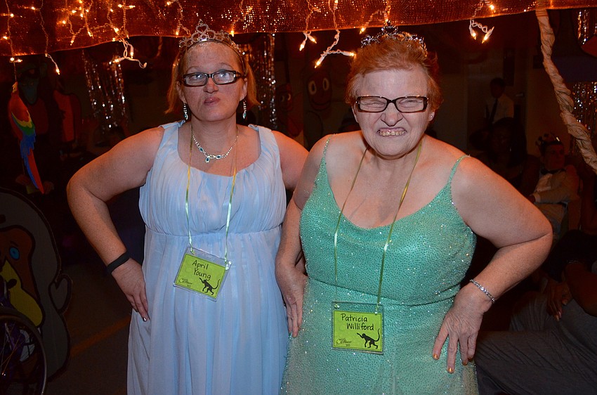 April Young and Patricia Williford sport matching smiles and long formal gowns.