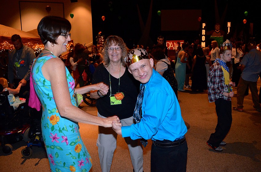 Ann Barrow and Ceil Dyr help Zak Barlow dance to the music.
