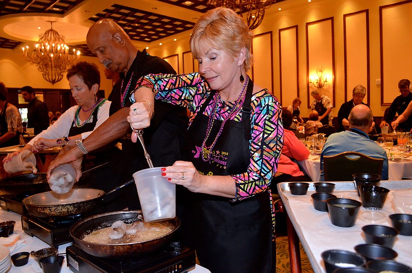 Laurie Coleman focuses on sautéing shrimp for her tablemates.