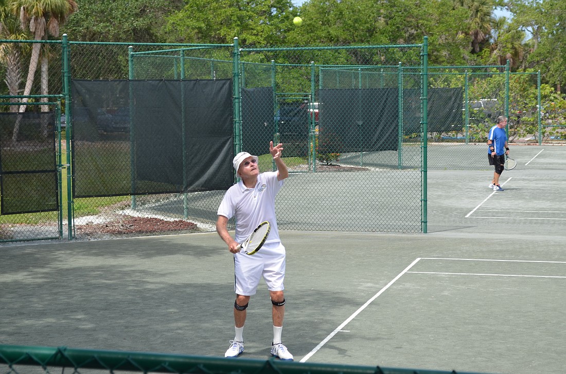 Longboat Key Public Tennis Center member Andy Thoms serves the ball during a game Monday.