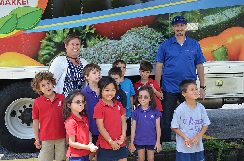 Teacher Shonna Brady with her students in front of the All Faiths Food Bank Sprout Mobile Farm Market with Ryan Beaman.