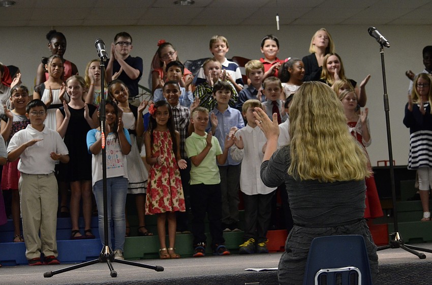 Tiffany Greer, one of the fourth-grade teachers, helps her students along with the performance.
