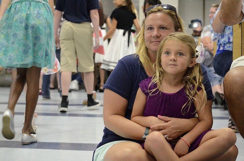 Merina Earl, 5, and her mom, Kristin, watch the fourth-graders walk down into the audience for a dance.