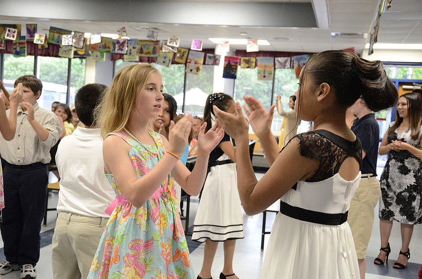 Olivia Henderson and Xenaida Conde perform the pioneer washerwoman dance.