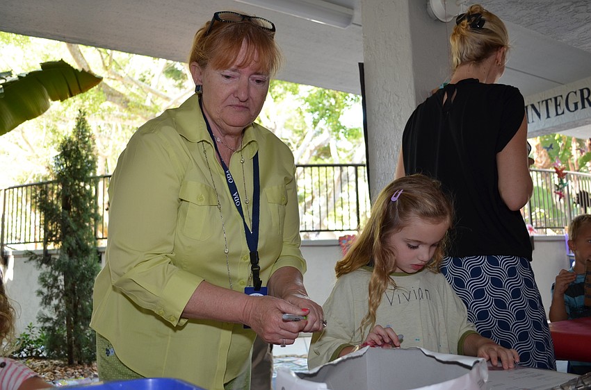 Substitute teacher Sally Schmitt helps students with one of the art stations.
