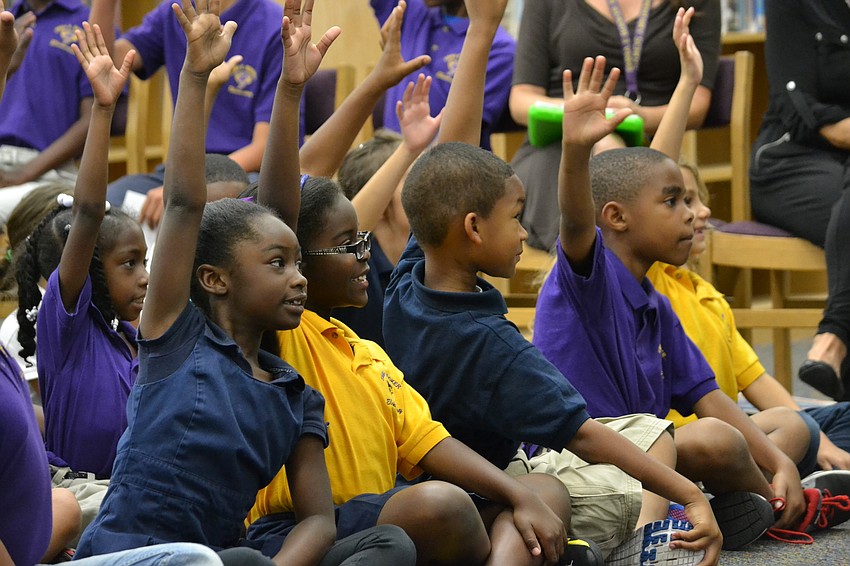 Students raise their hands in respons to LeVar Burton asking if they have seen “Reading Rainbow.”