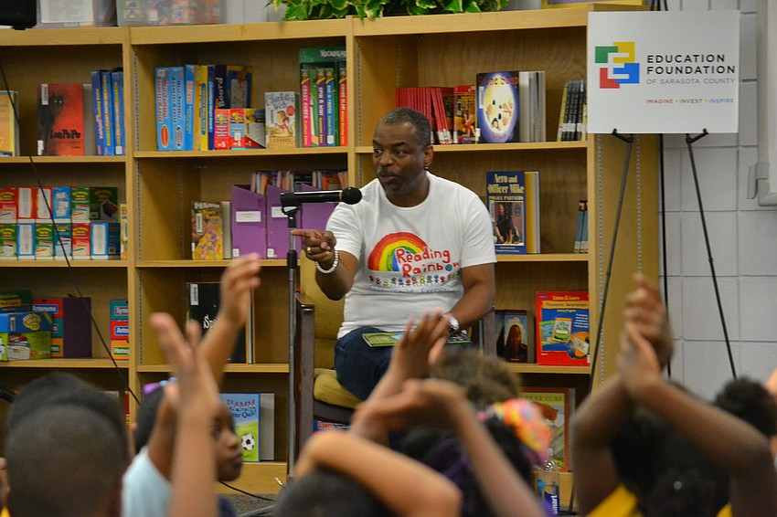 Students raise their hands and ask questions for Burton.